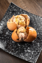 棕色木纹桌上放着一盘毛蛋