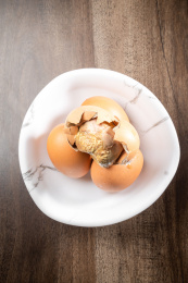 棕色木纹桌上放着一盘毛蛋