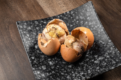 棕色木纹桌上放着一盘毛蛋