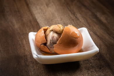 棕色木纹桌上放着一盘毛蛋