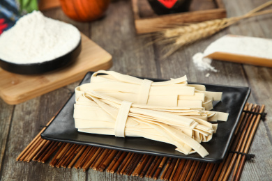 竹垫上放着一盘手工宽面