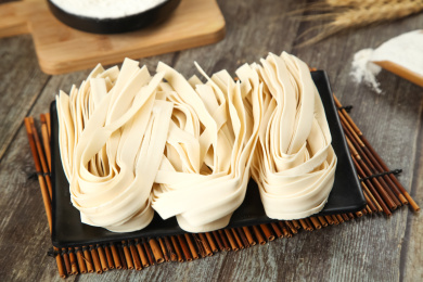 竹垫上放着一盘宽面条