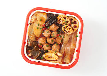 白色背景上摆放的牛油鸭血火腿自热小火锅