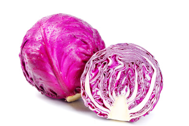 白底上放着一个完整的红甘蓝和半边紫包菜
