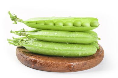 白底木垫上放着一堆青豆荚