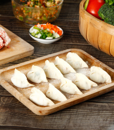 木底上放着一盘包好的三鲜馅饺子