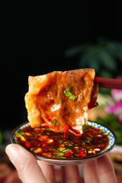筷子夹起一片熟肉卷放到碟子里蘸酱
