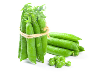 白底上放着一堆鲜豌豆和一捆青豆荚