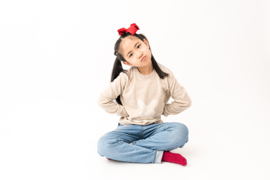 坐在白色背景前玩耍的中国女孩