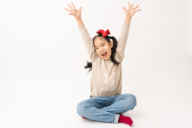 坐在白色背景前玩耍的中国女孩