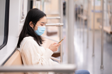 戴着口罩通勤坐地铁的年轻女性