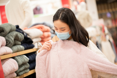 年轻长发美女戴口罩逛街买衣服