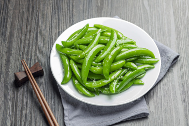 家常菜清炒甜豆摆放在木桌面上特写