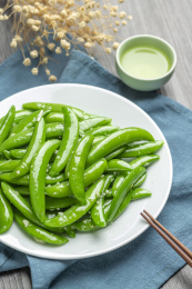 家常菜清炒甜豆摆放在木桌面上特写