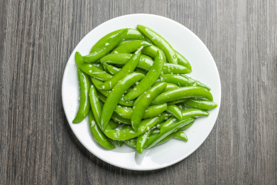 家常菜清炒甜豆摆放在木桌面上特写