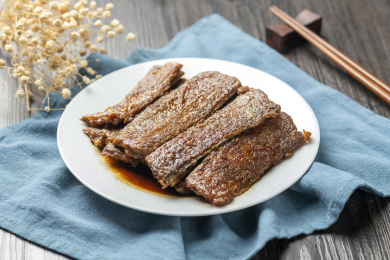 红烧带鱼摆放在木桌面上特写深色调