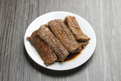 红烧带鱼摆放在木桌面上特写深色调