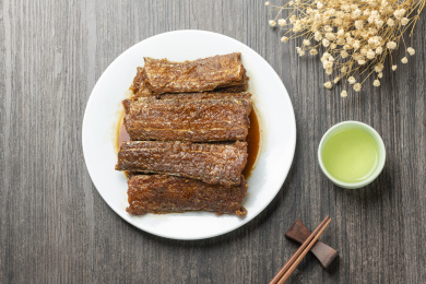 红烧带鱼摆放在木桌面上特写深色调