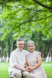 幸福的老年夫妇坐在户外公园的椅子上