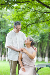 幸福的老年夫妇坐在户外公园的椅子上