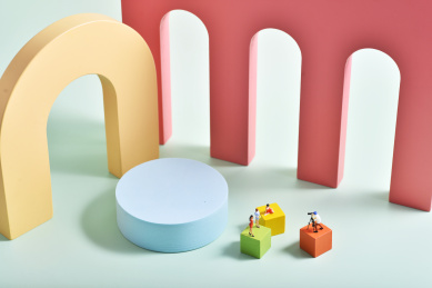 明亮背景上的几何图形与微缩小人的创意摄影