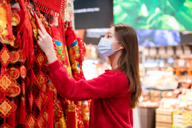 年轻女性在超市挑选采购新年装饰品
