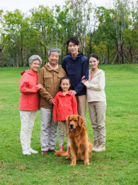 快乐的五口之家和宠物狗在公园合影