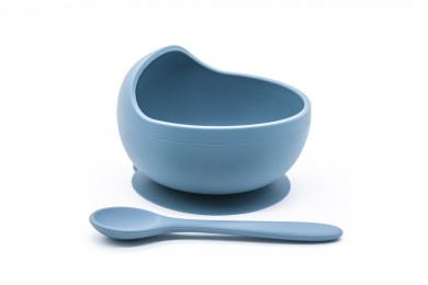 白色背景上的各色婴幼儿用硅胶餐具碗与勺