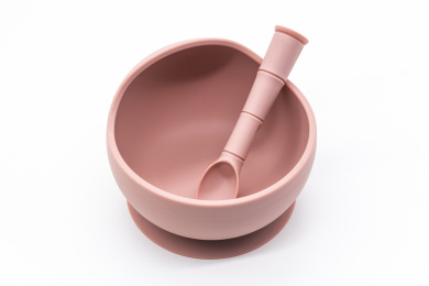 白色背景上的各色婴幼儿用硅胶餐具碗与勺