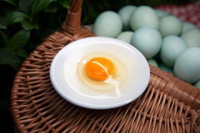 放在鸡蛋筐上的一碟蛋黄蛋清