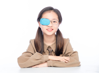 白色背景里，带着弱视眼罩的亚洲小女孩