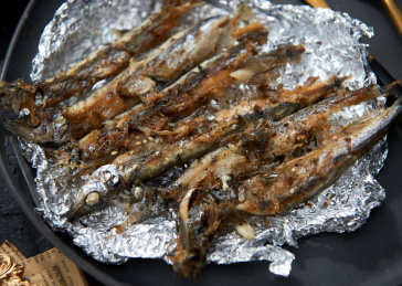 餐具上盛放的香煎多春鱼