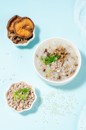 浅色背景下放在蓝色卡纸上的香菇瘦肉粥