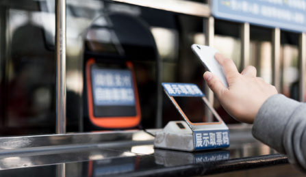 佩戴口罩的女子使用手机购票