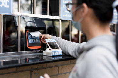 佩戴口罩的女子使用手机购票