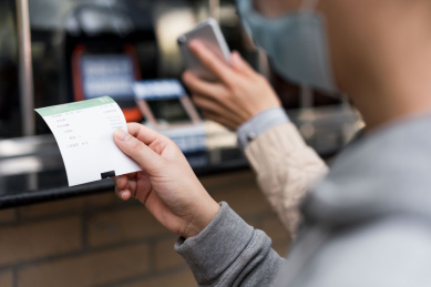佩戴口罩的女子使用手机购票