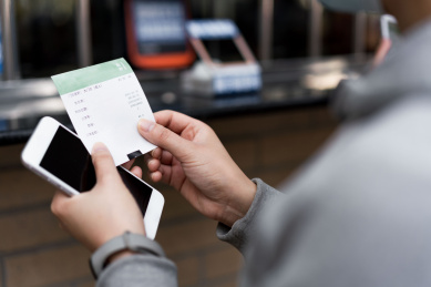 佩戴口罩的女子使用手机购票