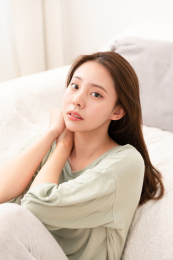 甜美女生穿着居家服靠着沙发坐着