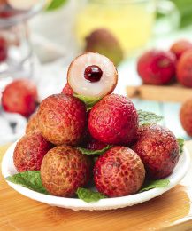 木板上放着一盘新鲜荔枝