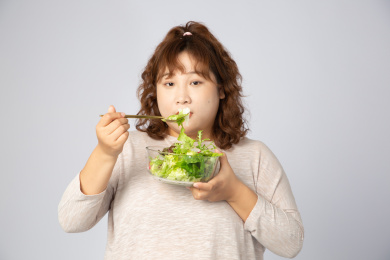 吃沙拉的亚洲肥胖女孩