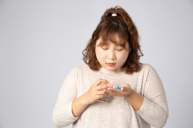 正在吃药的亚洲肥胖女孩