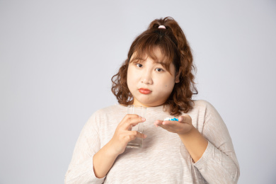 正在吃药的亚洲肥胖女孩