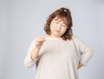 手拿验孕棒意外怀孕的亚洲肥胖女孩
