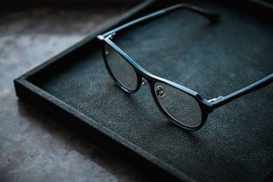 暗色桌面上放着一付眼镜架