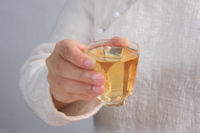 女生手拿一玻璃杯茶的特写