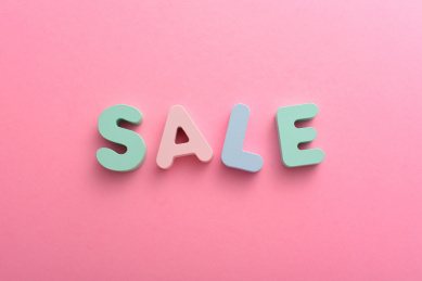 粉色背景上的彩色字母积木SALE