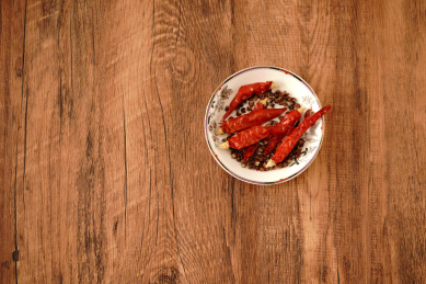 实木桌上摆着一叠尖椒干与花椒