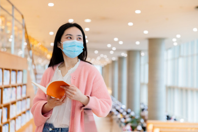 戴着口罩的同学在图书馆里学习