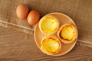 实木桌上摆着的一盘葡式蛋挞