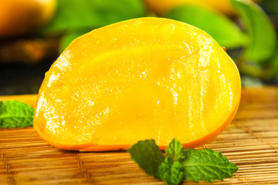 竹底上放着半边切开的小台农芒果